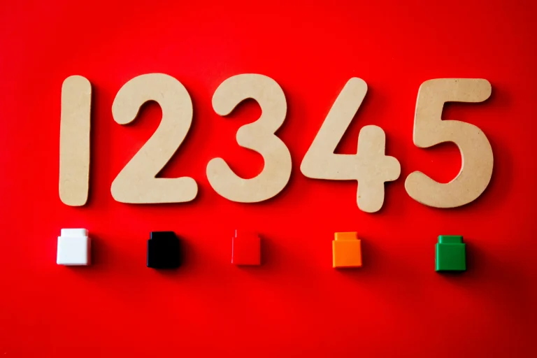 Wooden numbers 1 to 5 arranged on a red background, each paired with a coloured block for visual learning.