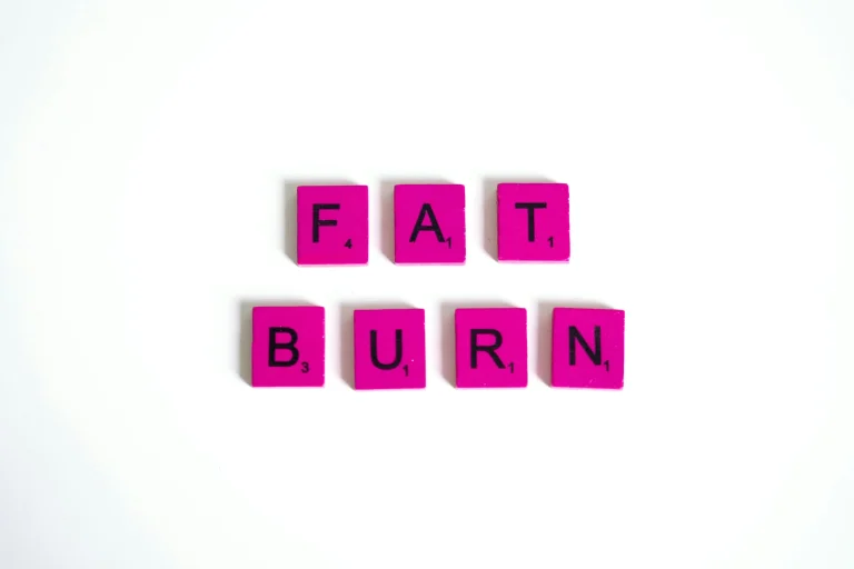 Pink letter tiles spelling out the words “fat burn” on a white background