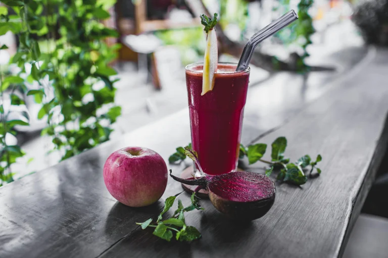 Glass of fresh beetroot and apple juice with mint garnish