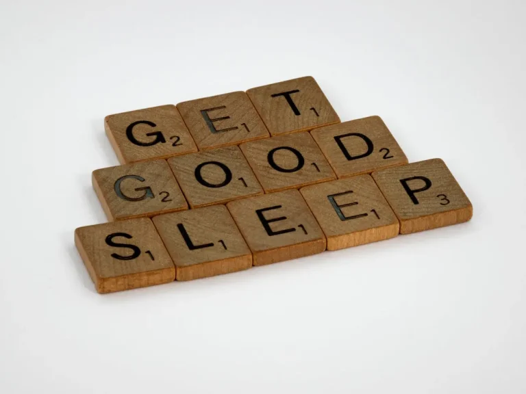Wooden Scrabble tiles spelling out the phrase Get Good Sleep on a white background