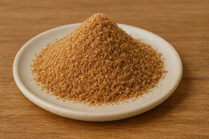 Close-up of ground flaxseeds piled on a ceramic plate over a wooden surface