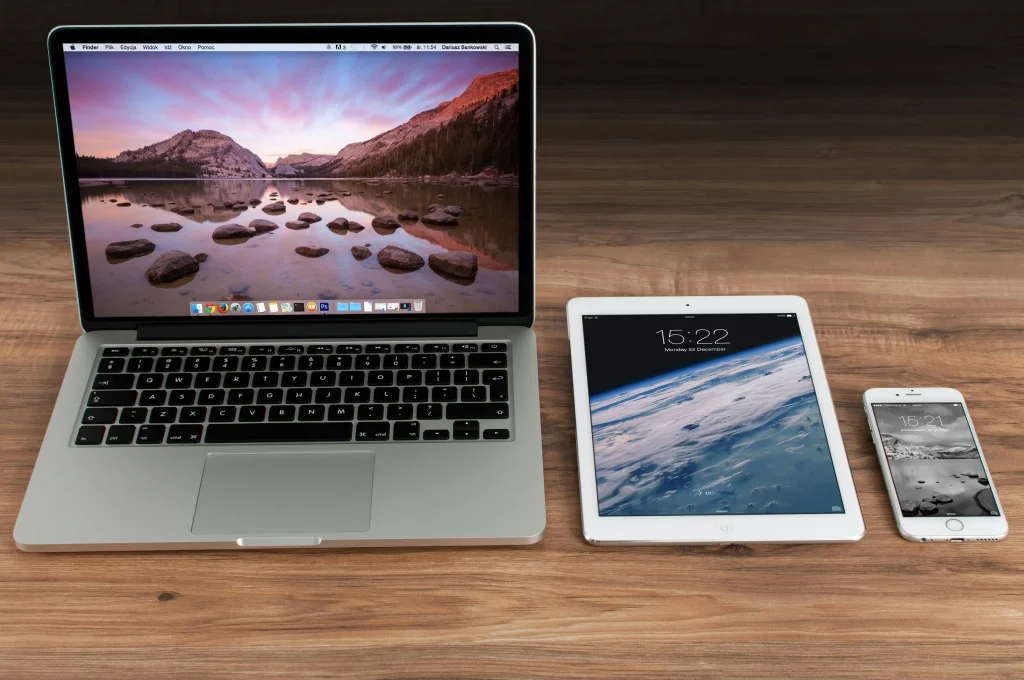 Modern laptop, tablet, and smartphone placed on a wooden desk