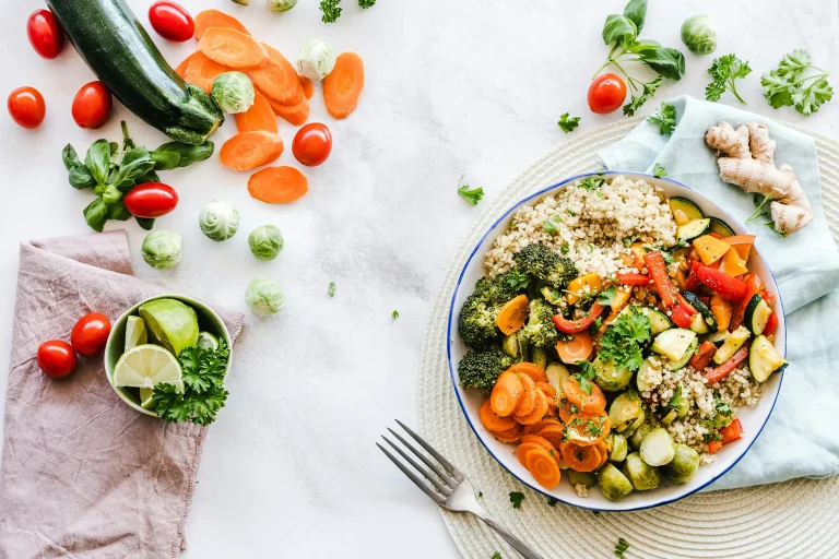 Quinoa bowl with broccoli, carrots, zucchini, peppers, and fresh herbs