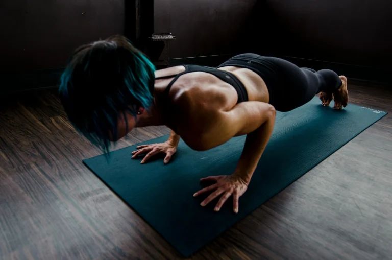 Athletic woman practicing yoga push-up pose for strength