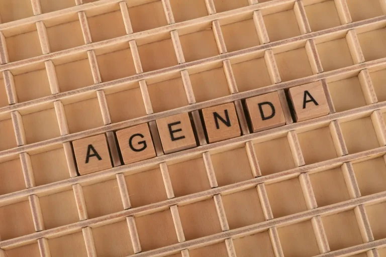 Wooden letter tiles spelling “AGENDA” on a grid tray for planning and organization